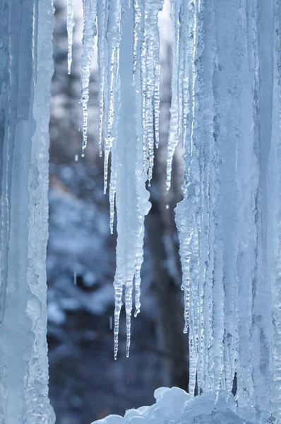 Een bevroren waterval met ijs in een blauwe en witte kleur in de winter — Stockfoto