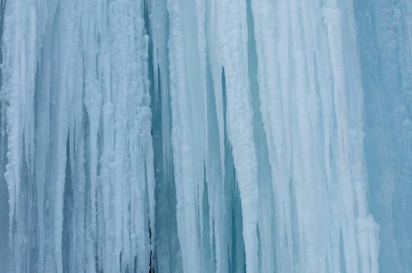 Ein gefrorener Wasserfall mit Eis in blau-weißer Farbe im Winter — Stockfoto
