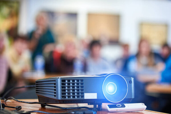 Working projector at the conference hall. Blurred people at background.