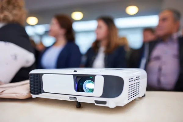 Projector de trabalho na sala de conferências. Pessoas desfocadas no fundo . — Fotografia de Stock