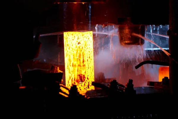 Forjamento de metal. martelo hidráulico molda o tarugo quente vermelho. a produção de peças de alta tecnologia — Fotografia de Stock
