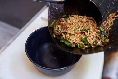 Tavada sebzeli erişte pişirme işlemi, geleneksel Asya yemekleri.