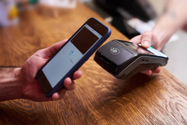 Cliente pagando por smartphone com tecnologia NFC — Fotografia de Stock
