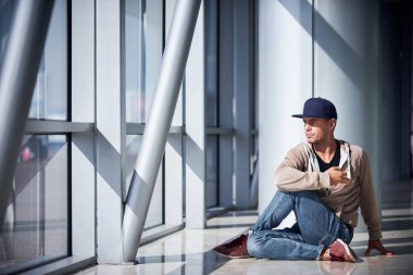 Genç adam boş havaalanı koridorunda yoga yapıyor..
