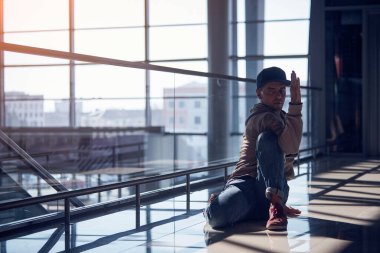 Genç adam boş havaalanı koridorunda yoga yapıyor..