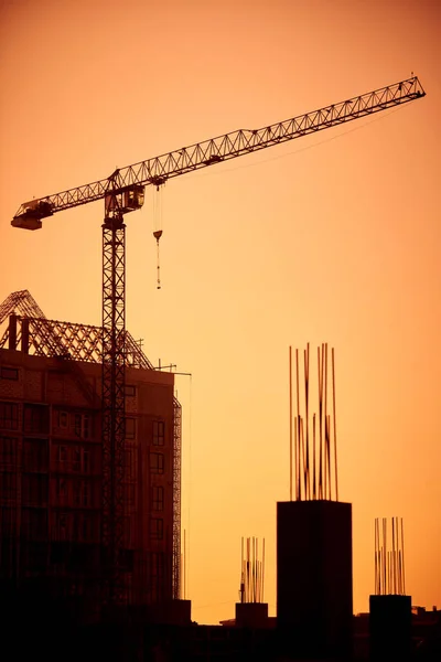 Sylwetka Żurawia Wieżowego Placu Budowy Tłem Budynku Miejskiego — Zdjęcie stockowe