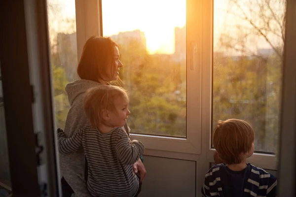 Μητέρα Δύο Γιους Κοιτάζει Έξω Από Παράθυρο Ηλιοβασίλεμα Στην Απομόνωση — Φωτογραφία Αρχείου