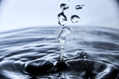 Kaynar su mavi arkaplanda buharla sıçrar..