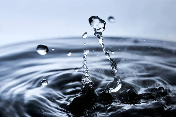 Kaynar su mavi arkaplanda buharla sıçrar..