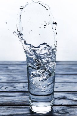 İçilecek su mavi arka plandaki bir bardağa döküldü.