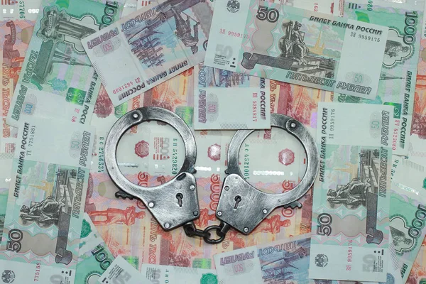 Handcuffs against the background of Russian money — Stock Photo, Image