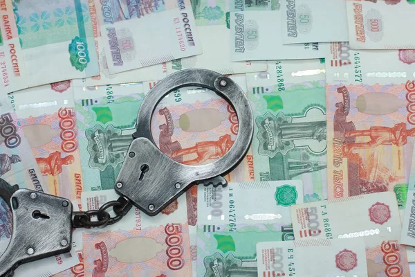 Наручники лежат на русских деньгах — стоковое фото