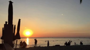 Çocuklar gün batımında sahilde oynarken.