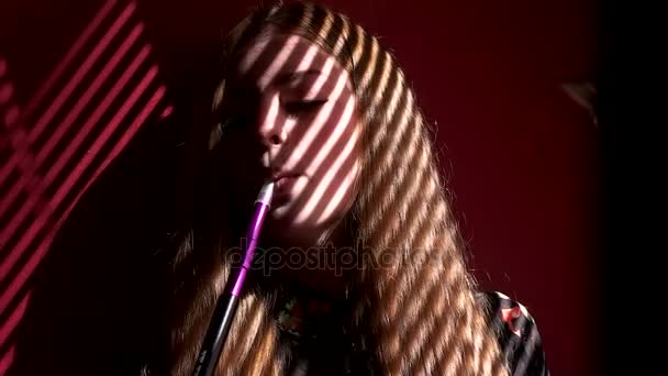 Femme fume une chicha à la fenêtre un feu arrière 