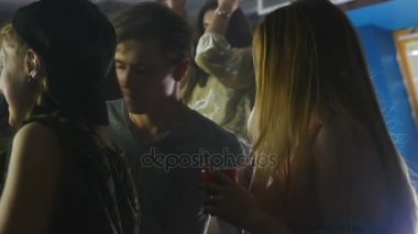 Genç bir kız sigara bir nargile ve bir parti insanlar tarafından çevrili dansları