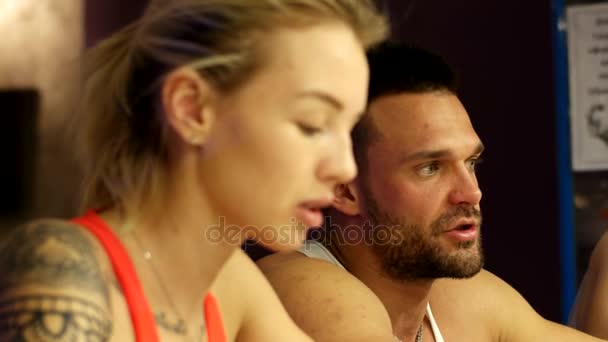 Tres entrenadores están charlando en el bar del gimnasio — Vídeo de stock