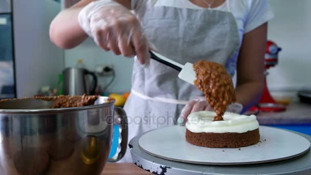 Girl puts chocolate cream on a cake — Stock Video