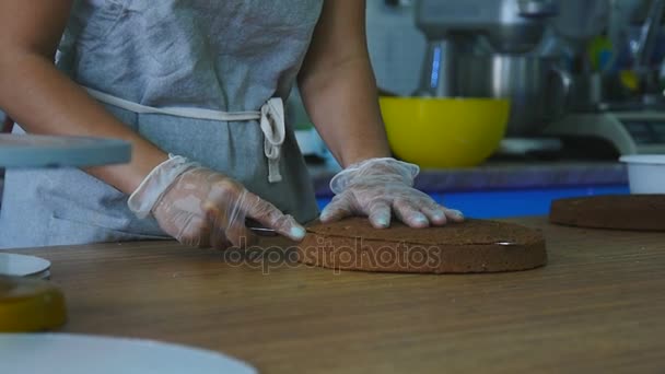 Het meisje snijden de taart in de keuken — Stockvideo