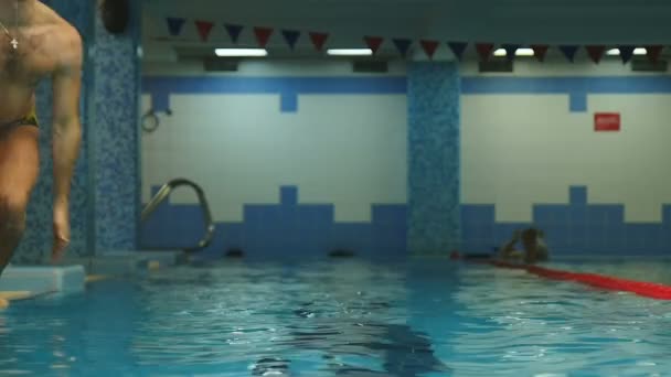 Tipul a sărit într-o piscină cu apă albastră limpede — Videoclip de stoc