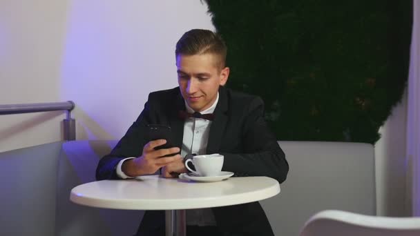 Jovem usando smartphone em um café — Vídeo de Stock