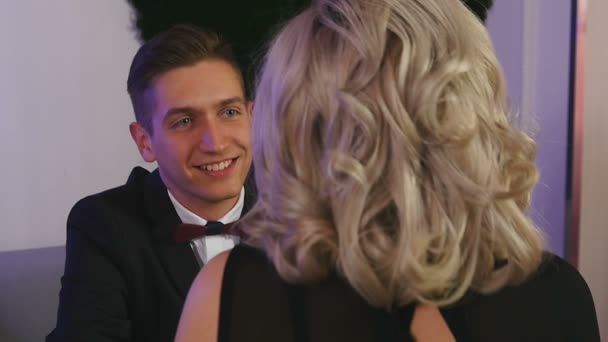 Smiling young man talking to his girlfriend and laughing at a table in a cafe — Stock Video