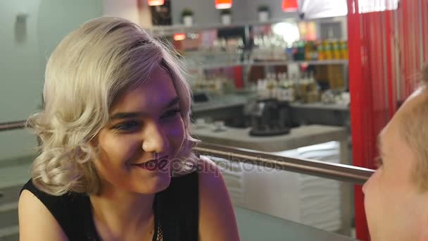 Mädchen hört ihrem Freund an einem Tisch in einem Café zu — Stockvideo