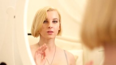 Genç kadının saçını düzeltiyor aynada yansıması