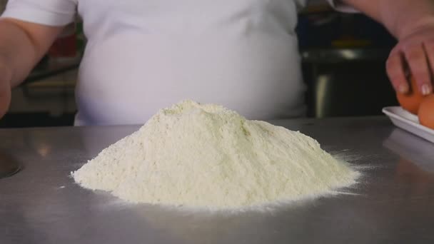 Side view chef przerwy jajko z nożem i zgłasza je do mąki — Wideo stockowe