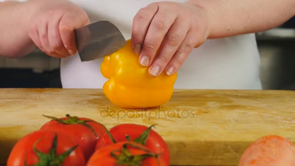 Mujer vista lateral cocinero corta pimiento bulgaro en rodajas en una tabla de cortar — Vídeo de stock