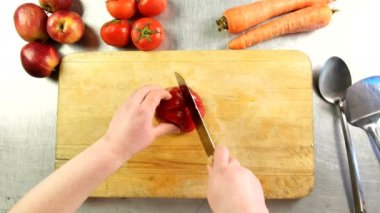 Üstten Görünüm Şef Bulgar biber dilimleri içine bir kesme tahtası üzerinde keser.