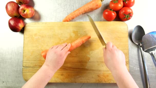 Top view cook cuts carrot into slices on a cutting board — Stock Video