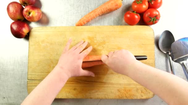 Top vista mulher cozinheiro corta cenoura em meio-anéis em uma placa de corte — Vídeo de Stock