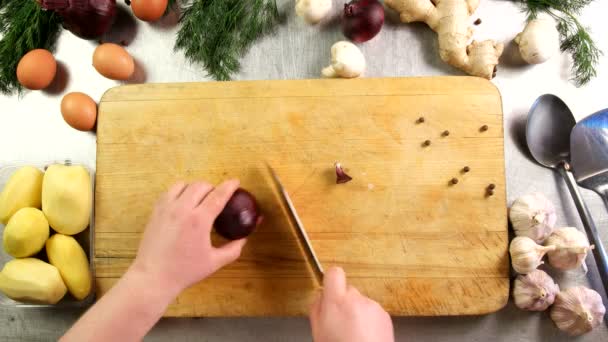 Kjøkkensjefen skjærer løk i halvringer på hakkebrettet – stockvideo