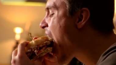 Yakın dostum ısırıkları ve bir kafede hamburger yiyor