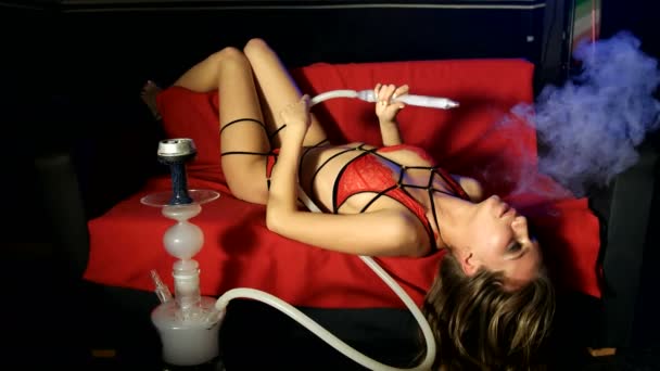 Sexy menina fuma shisha no escuro quarto — Vídeo de Stock