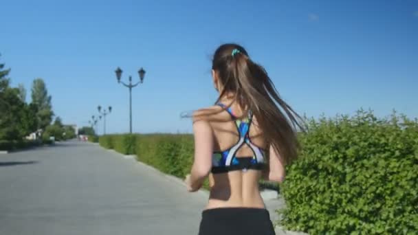 Back view sports woman runs down an empty street — Stock Video