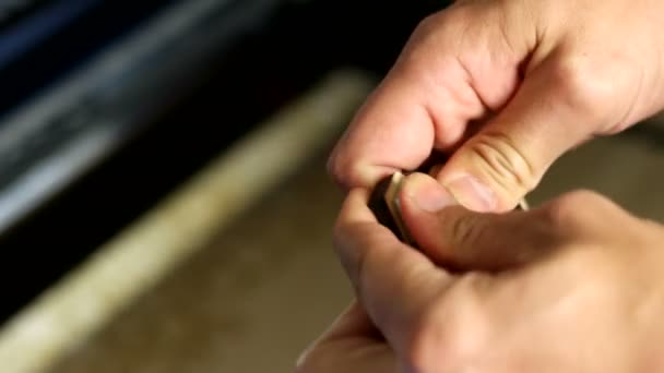 Man inserts female screw into a wooden spinner — Stock Video