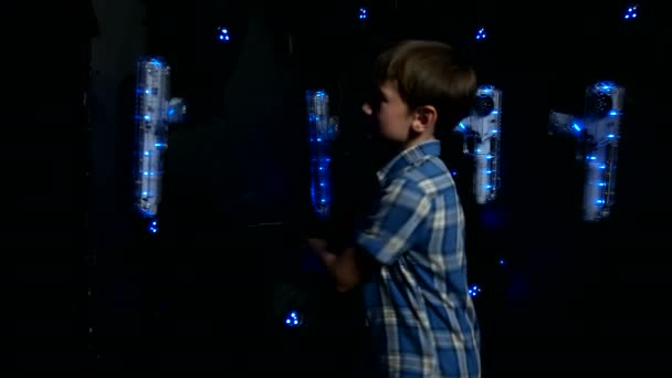 Boy puts on the equipment for playing laser tag — Stock Video