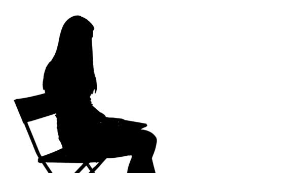 Женщина садится на стул и использует силуэт ноутбука — стоковое видео