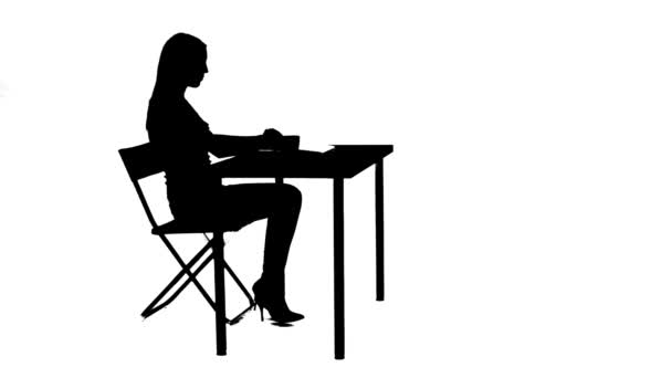 Menina senta-se à mesa bebe chá e usa uma silhueta laptop — Vídeo de Stock