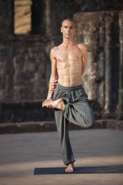 Genç adam yoga yapar.