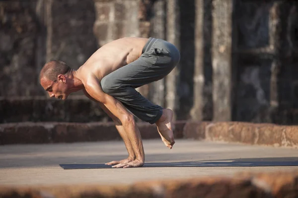 Genç adam yoga yapar.
