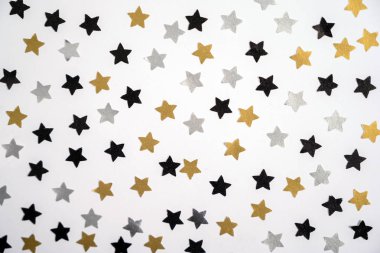 Beyaz arka planda gümüş, altın ve siyah yıldızlar. Noel süsü. Kış tatili konsepti. Noel kartı..