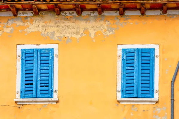 一座蓝色百叶窗的黄色旧房子的立面。克罗地亚 — 图库照片