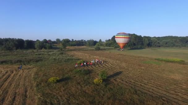 Menschen gehen zu Heißluftballon, der sich auf den Flug vorbereitet. — Stockvideo