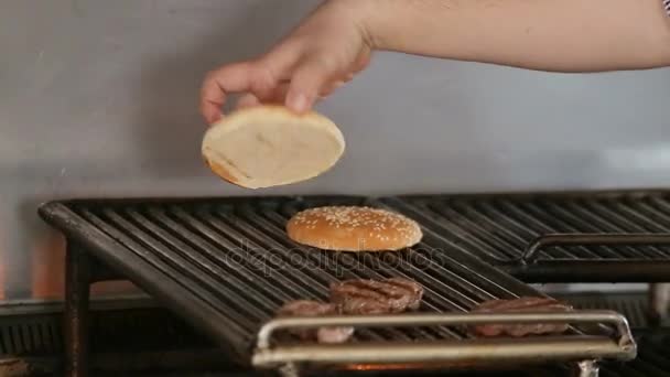 Cocinar pan de hamburguesa en una parrilla . — Vídeos de Stock