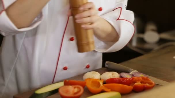 Frau würzt Gemüsesalat mit Salz, Nahaufnahme — Stockvideo