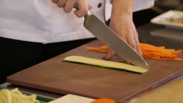 Mano con un coltello tagliate zucchine per pasta vegetale — Video Stock