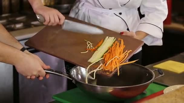 Mano con un coltello spostare le verdure in padella — Video Stock