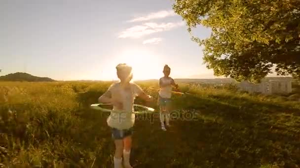 Δύο παιδιά κορίτσια παίζουν με hula-hoop — Αρχείο Βίντεο